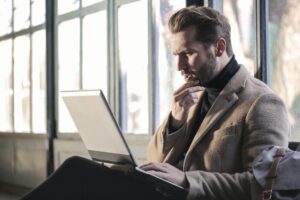 Man looking at laptop confused